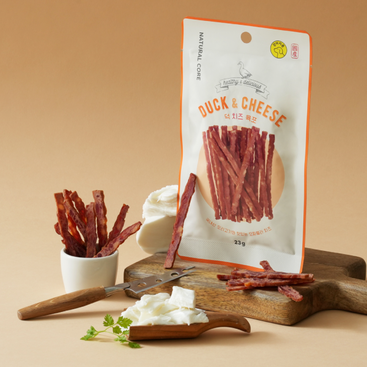 Duck and cheese snack sticks with packaging on a beige background